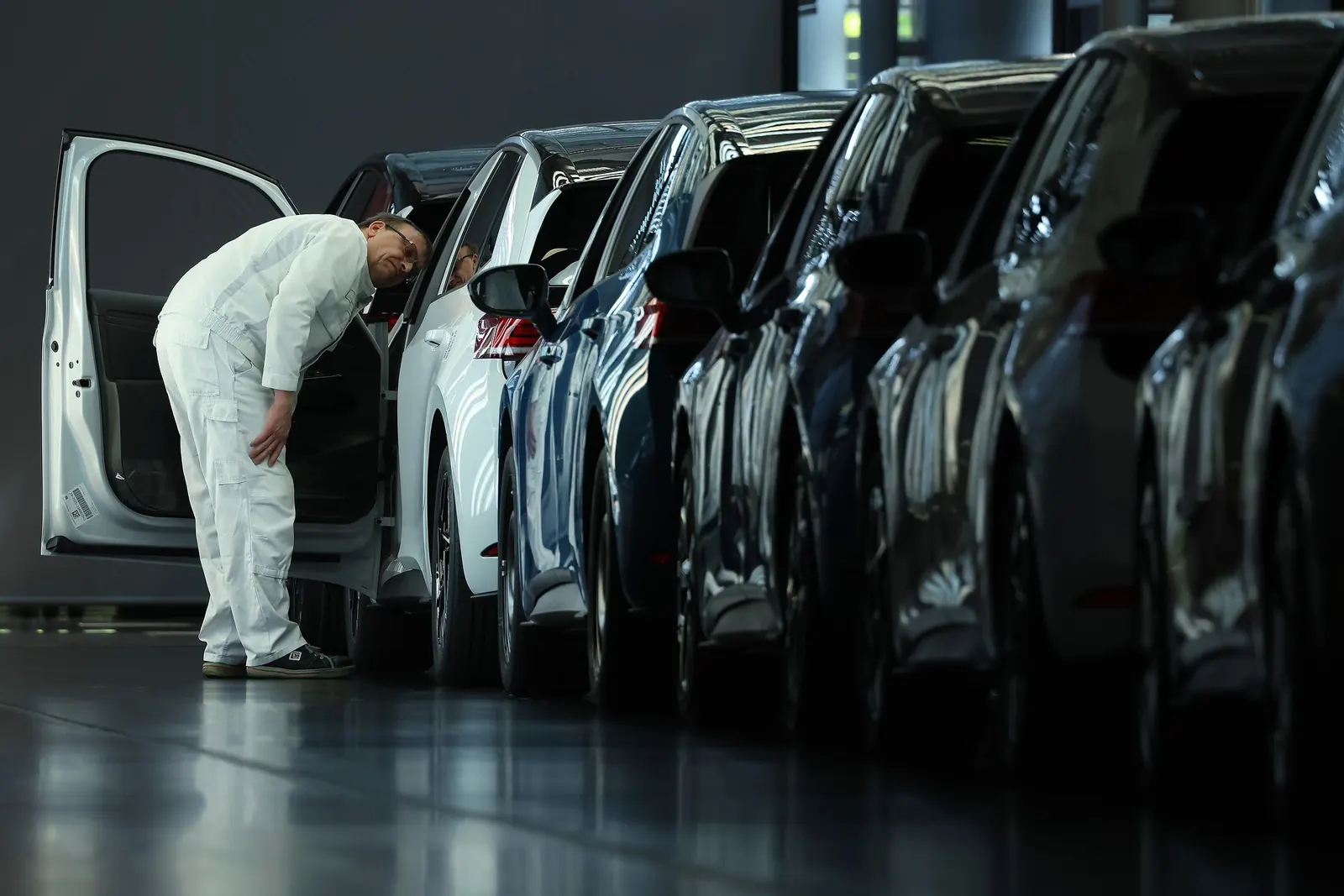 Рабочий на заводе Volkswagen в Германии, собирающий автомобиль