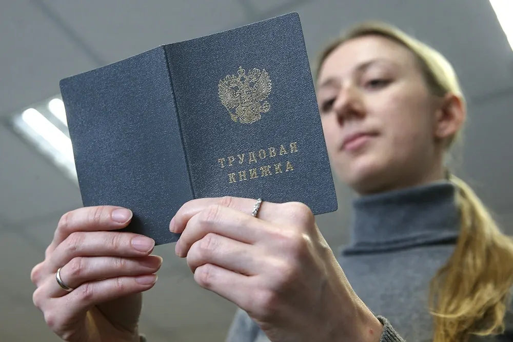 Молодой специалист на стажировке в офисе, изучает документы с наставником